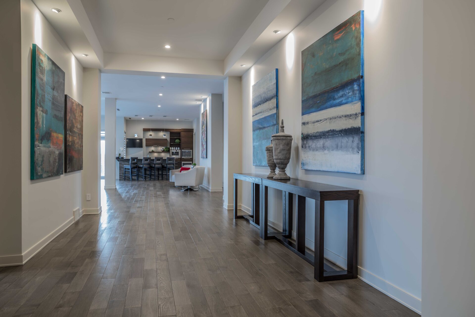 Modern open concept living and kitchen area with large abstract paintings and contemporary furniture