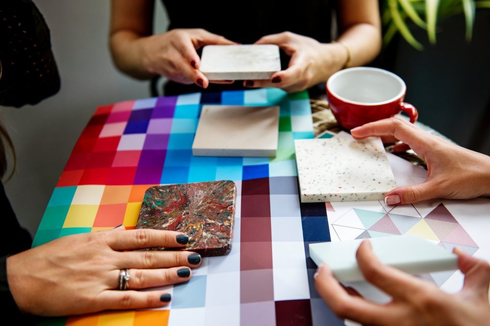 Interior designer selecting from colorful material and paint swatches at a desk
